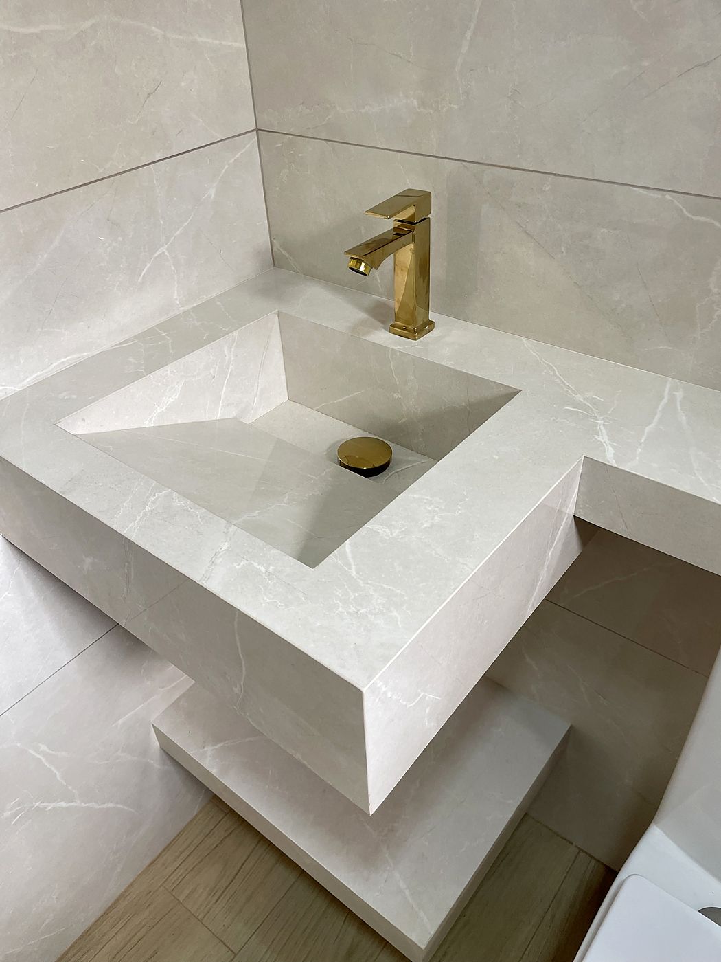 Lavabo com cuba esculpida e metais dourados