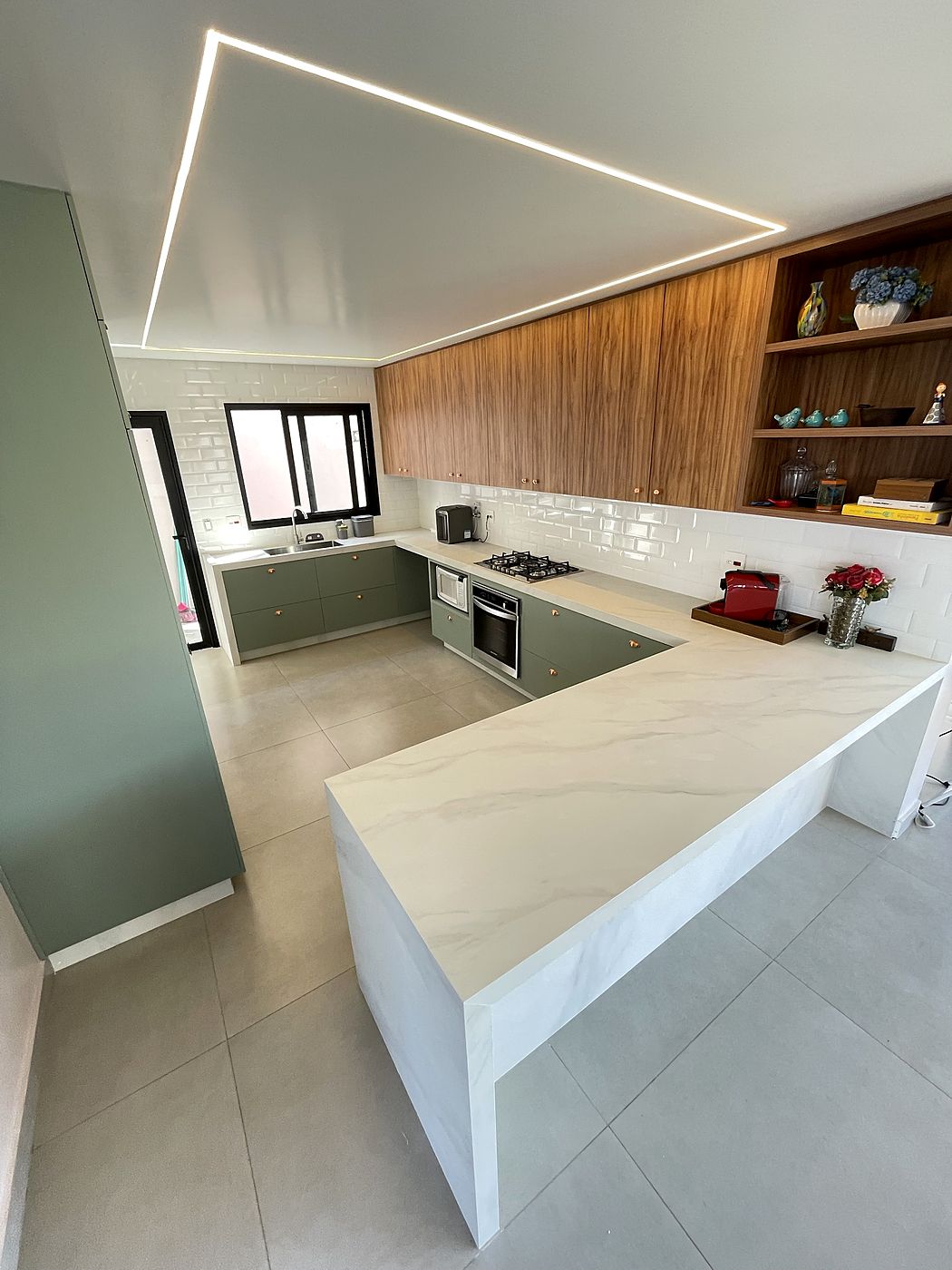 Cozinha em U com bancada branca e laterais até o piso